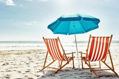 Liegestühle mit Sonnenschirm am Strand