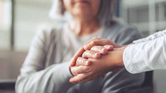 junge Hand hält Hände der alten Frau